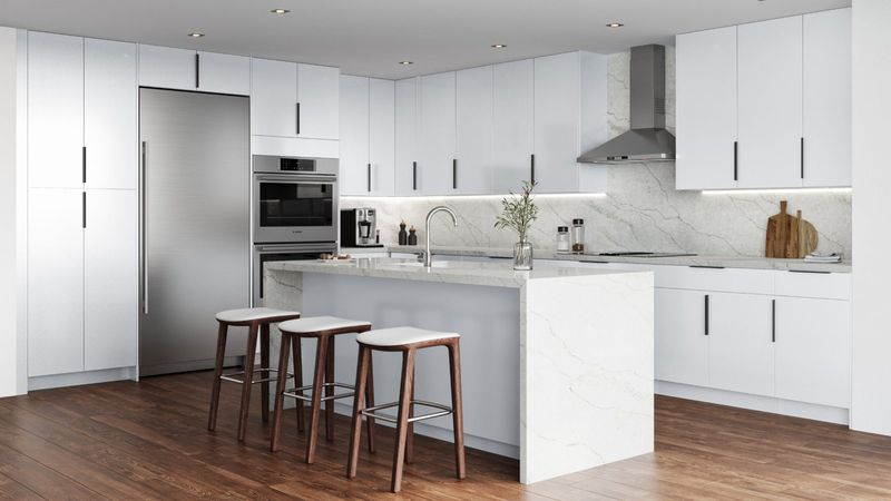 Modern matte white slab-door kitchen with quartz waterfall island
